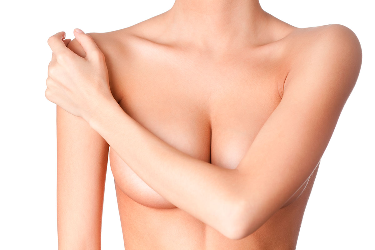 Frau hält Arm vor Brust: Brustverkleinerung bei JUVENIS